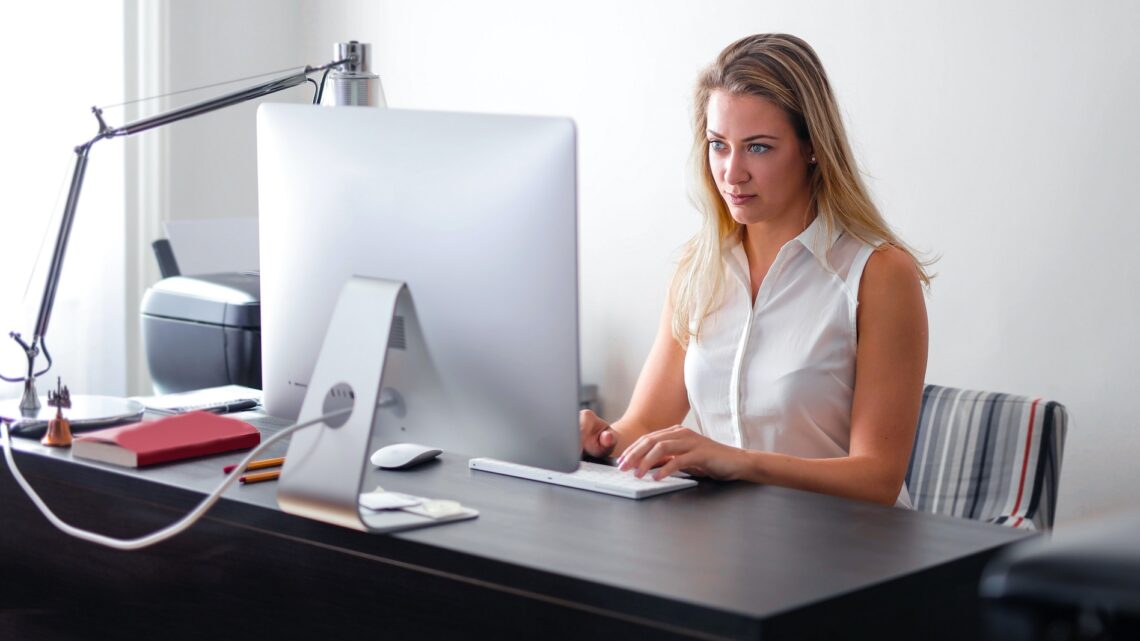 https://www.pexels.com/photo/woman-in-white-sleeveless-shirt-using-macbook-air-on-brown-wooden-table-3766189/